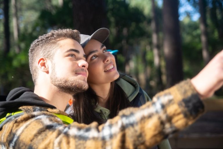 excited-couple-young-hikers-caucasian-man-with-beard-woman-cap-pointing-looking-up-hobby-nature-love-concept-1.jpg
